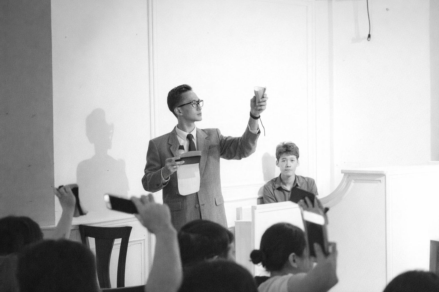 Mann versteigert Inventar während einer Auktion in Schwarz-Weiß.